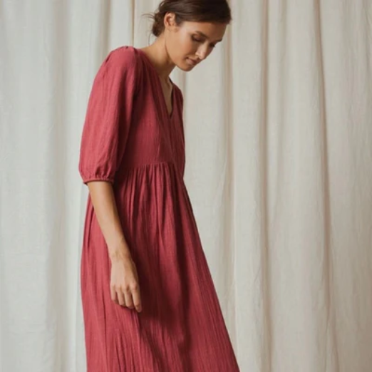 Clothing | Elizabeth Homestead (Model wearing full length cotton dress that is a red raspberry colour.)