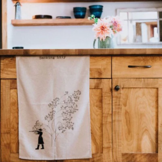 Kitchen | Elizabeth Homestead (Wooden cabinets in a kitchen with a tea towel with a fun design draped in front of cabinets door.)