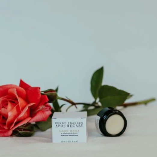 Ritual | Elizabeth Homestead (Small white box with writing sitting in front of a red rose with a jar of face balm placed on its side next to the white box.)