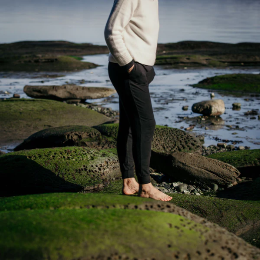 smoking lily | Elizabeth Homestead (model standing on rocks by the water wearing black pants and no shoes)